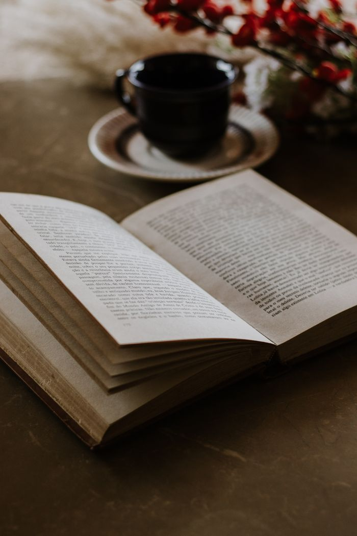 our-story An inviting scene with an open book and coffee cup, ideal for relaxation and reading.
